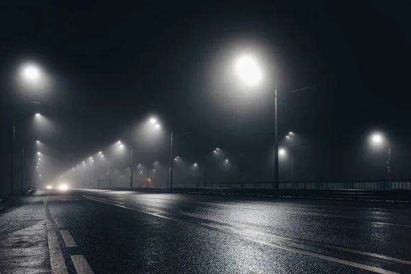 Foggy route brumeuse de nuit éclairée par des lampadaires — Photo