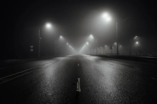 Nebbia nebbiosa strada notturna illuminata da lampioni — Foto Stock