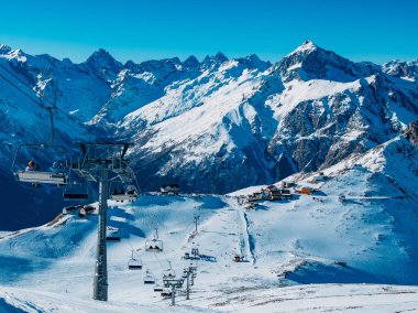 Mountain ski resort in winter sunny day. Ski slopes and cable car