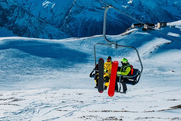 Stoel kabelbaan met snowboarders in de winter zonnige dag — Stockfoto