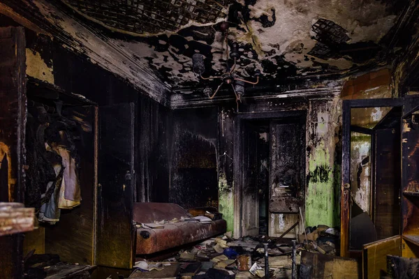 Abgebranntes Haus. Verbrannte Möbel, verkohlte Wände und Decken in schwarzem Ruß — Stockfoto