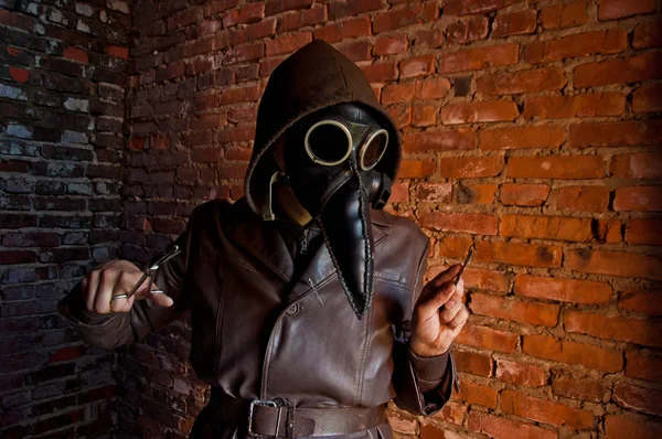 Terrible plague doctor on red brick background. Masked maniac with scalpel and scissors. Halloween and horror — Stock Photo, Image