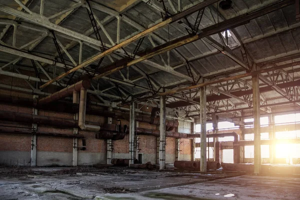 Old abandoned industrial building with rusty remnants of pipeline — Stock Photo, Image