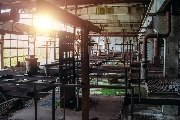 Stara opuszczona fabryka z zardzewiałymi resztkami maszyn przemysłowych w warsztacie — Zdjęcie stockowe