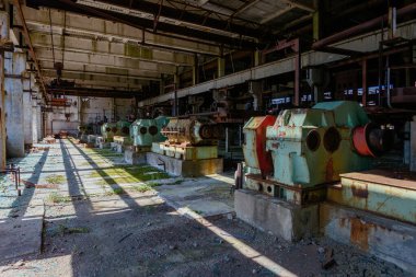 Atölyede paslı endüstriyel makine kalıntılarıyla terk edilmiş eski bir fabrika..