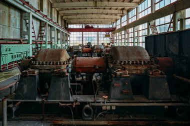 Atölyede paslı endüstriyel makine kalıntılarıyla terk edilmiş eski bir fabrika..