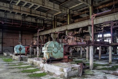 Atölyede paslı endüstriyel makine kalıntılarıyla terk edilmiş eski bir fabrika..