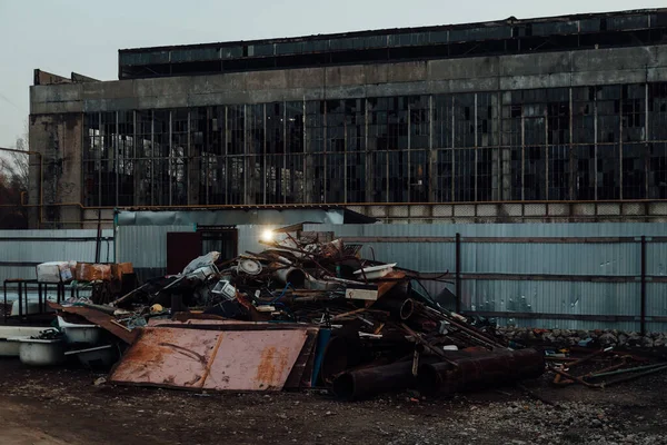 Pile of scrap metal on junk in abandoned industrial area.