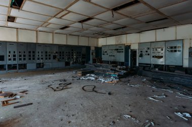 Terk edilmiş fabrikada kontrol panelleri olan kırık elektrik şalter dolapları..