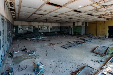 Terk edilmiş fabrikada kontrol panelleri olan kırık elektrik şalter dolapları..