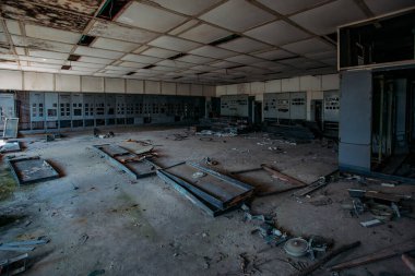 Terk edilmiş fabrikada kontrol panelleri olan kırık elektrik şalter dolapları..