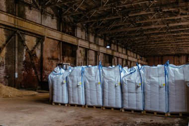Depoda fabrika ürünleriyle dolu beyaz polietilen çantalar..