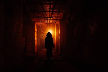 Koyu kırmızı ışıklı terk edilmiş binadaki ürkütücü siluet. Manyak kavramıyla ilgili korku.