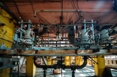 Eski paslı endüstriyel tanklar terk edilmiş kimya fabrikasındaki vanalara bağlı borularla birbirine bağlı.