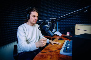 Radyo istasyonunda konuşan erkek radyo sunucusu.