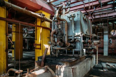 Eski paslı endüstriyel tanklar terk edilmiş kimya fabrikasındaki vanalara bağlı borularla birbirine bağlı..