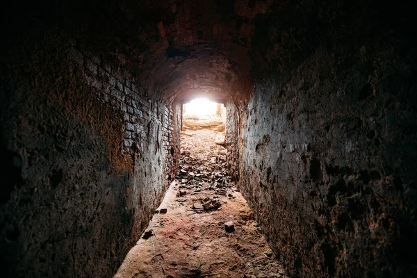 Pasaje histórico subterráneo de ladrillo rojo. Luz al final del túnel —  Fotos de Stock