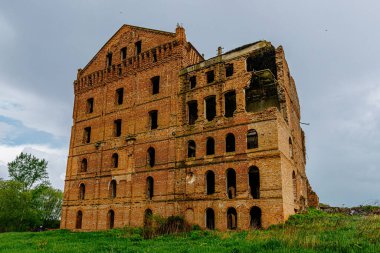 Terk edilmiş kırmızı tuğla sanayi binası, harap olmuş eski su değirmeni.