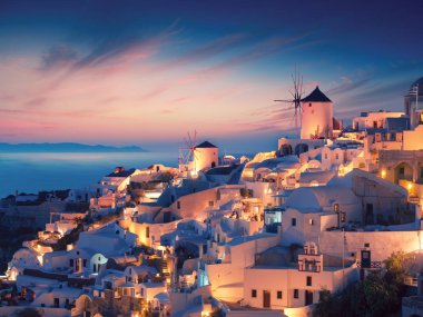 Oia Köyü Santorini Adası Yunanistan'ın Beyaz evleriyle muhteşem gün batımı görünümü.