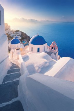 Yunanistan 'ın Santorini adasındaki Oia köyünde beyaz evler ile şaşırtıcı gün doğumu manzarası.