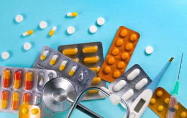 Mavi arka planda haplar ve işitme cihazı