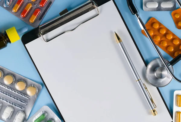 病気の診断 ペンと丸薬付きノートブルーの背景 — ストック写真
