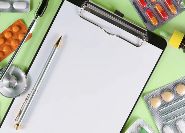 病気の診断 緑の背景にペンと薬とノート — ストック写真