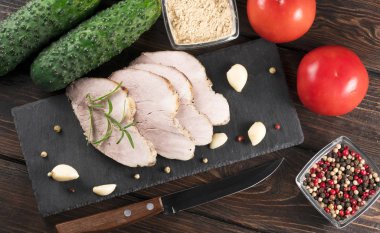 Ahşap arka planda domatesli tütsülenmiş et ve salatalık.