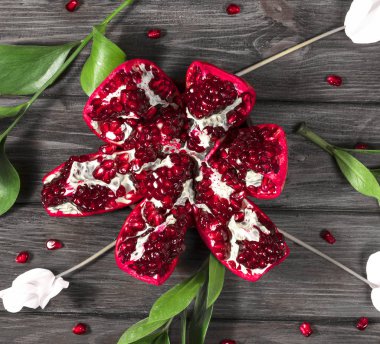 Tahta bir arka planda açık nar ve çiçekler