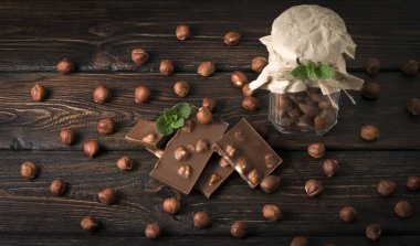 Fındıklı kavanoz ve tahta arka planda fındıklı çikolata.