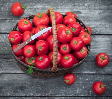 Tahta arka planda domatesli sepet.