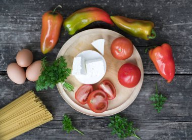 Spagetti, sarımsaklı domates ve gri ahşap arka plan..