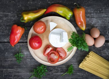 Spagetti, sarımsaklı domates ve gri ahşap arka plan..