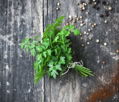 Gri ahşap arka planda taze maydanoz.