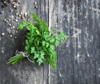 Gri ahşap arka planda taze maydanoz.