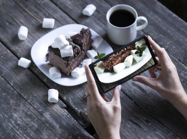 Tahta bir masada bir parça kek ve bir fincan kahve.