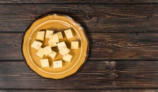 Kaasblokjes Een Bord Een Houten Ondergrond — Stockfoto