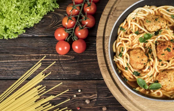 pasta with meat and chili tomatoes on wooden background