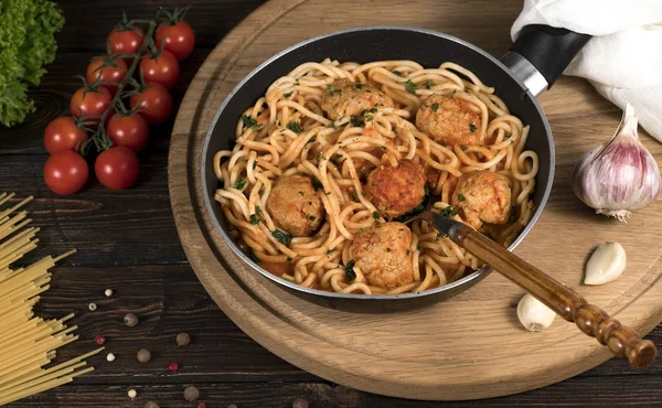 pasta with meat and chili tomatoes on wooden background