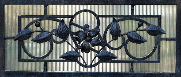 Details, structure and ornaments of forged iron gate. Floral decorative ornament, made from metal