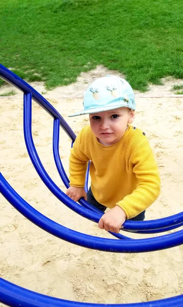 the boy  climbs the stairs on the Playground, close-up