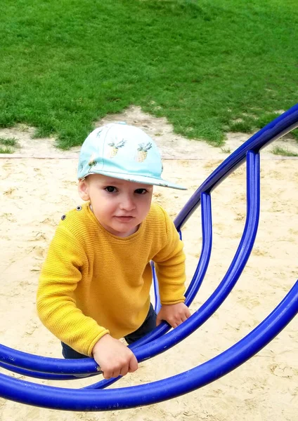 the boy  climbs the stairs on the Playground, close-up