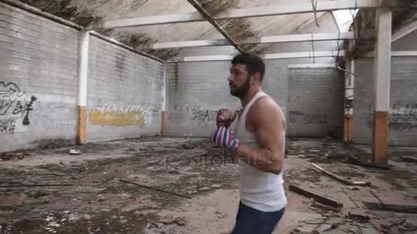 Joven boxeador masculino haciendo ejercicio de boxeo en la sombra . — Vídeo de stock