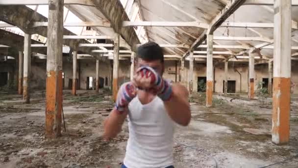 Joven boxeador masculino haciendo ejercicio de boxeo en la sombra . — Vídeos de Stock