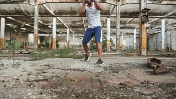 Joven boxeador masculino haciendo ejercicio de boxeo en la sombra . — Vídeos de Stock