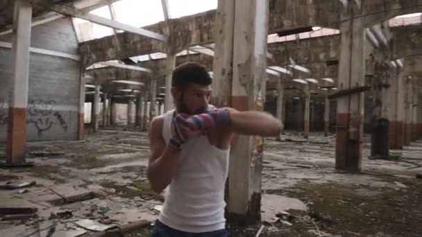 Joven boxeador masculino haciendo ejercicio de boxeo en la sombra . — Vídeo de stock