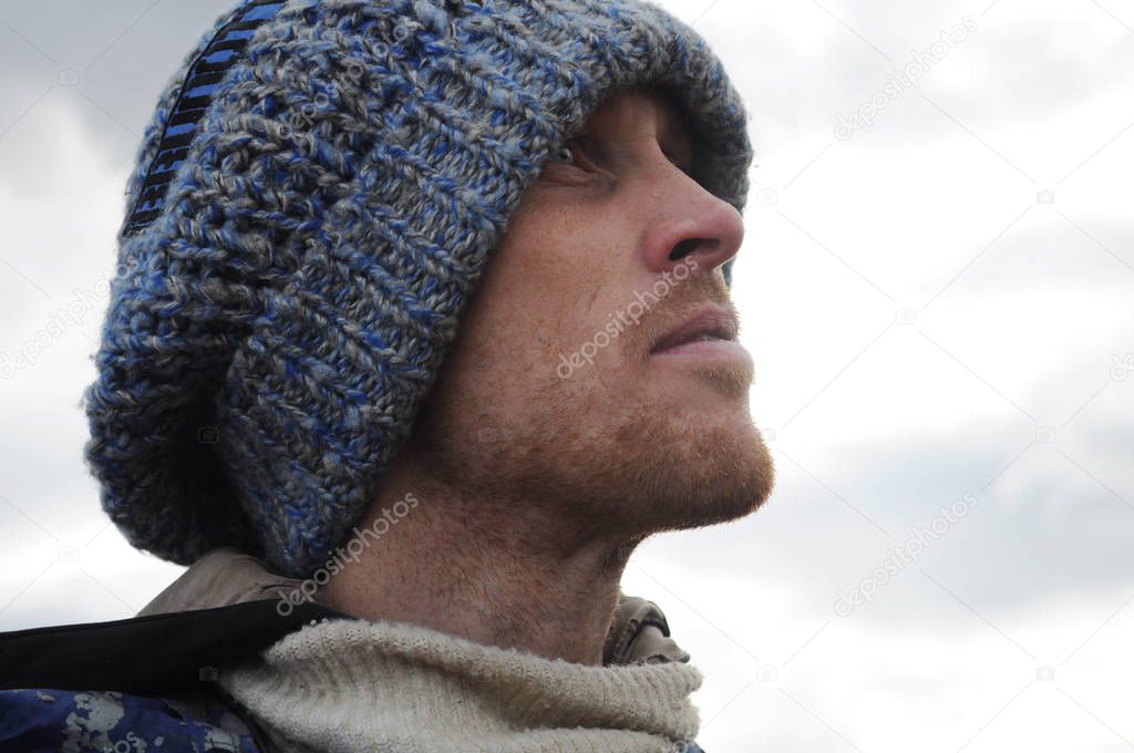 cute portrait of a man in a hat looks into the distance