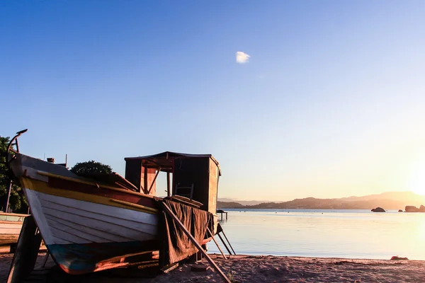 Günbatımı ve balıkçı teknesi Abraao plajda (Florianopolis - Brezilya) — Stok fotoğraf