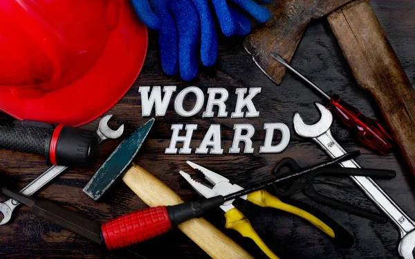 Tools and work hard written with letters on the wooden table which represent the popular phrase as lifestyle concept.