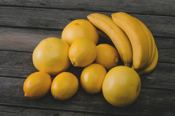 Bos van vers geel fruit op een oud houten tafel. — Stockfoto